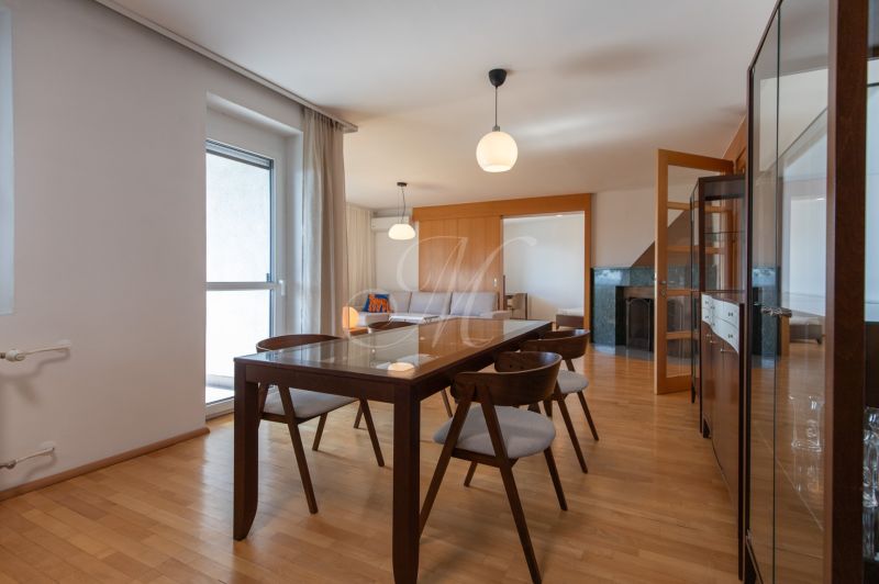 A stylish dining room with wood-patterned flooring and modern furniture in a 4-room apartment.