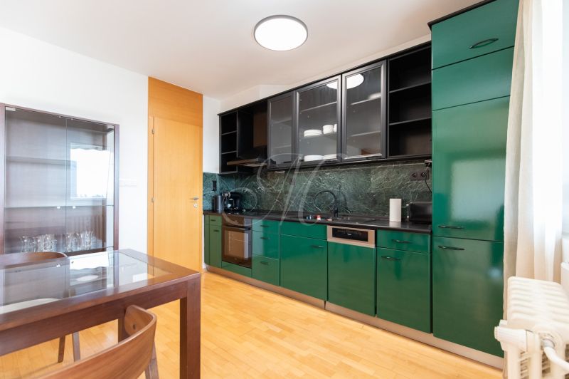 A kitchen with green cabinets, a dining table, and a wooden decor floor in a 4-room apartment.