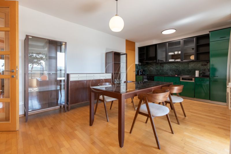 Dining area in a 4-room apartment with modern furniture and wooden decor flooring.