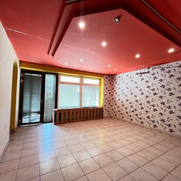 Commercial space with a red ceiling, tiled floor, and floral wallpaper.