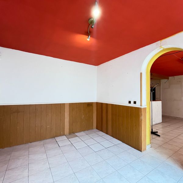 Interior of commercial premises with a red ceiling, white walls, and tiles.