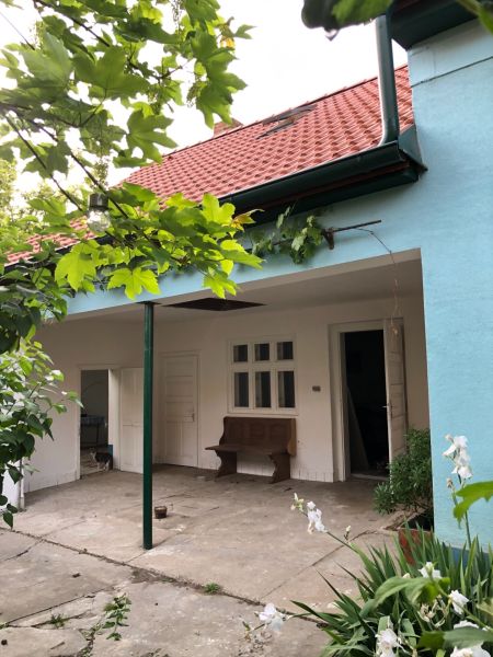 A family house in Majcichov on Majcichov Street with a garden, a bench, and a red roof.