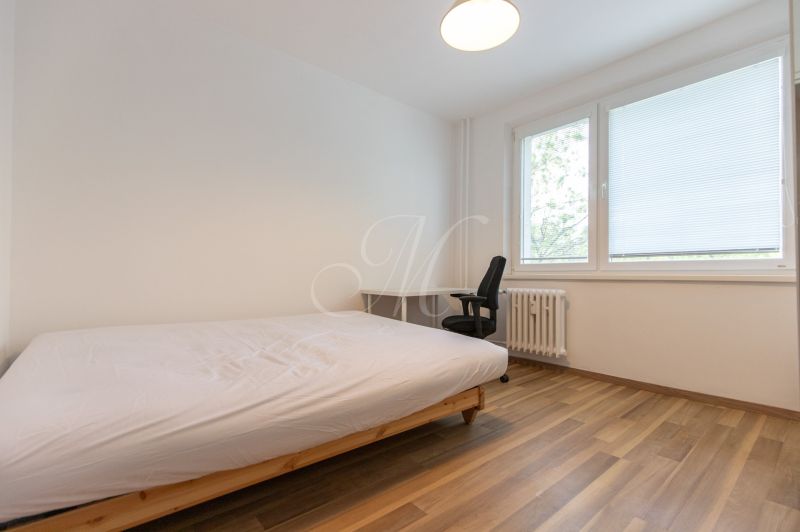 A bedroom with a single bed, a desk, and a wooden decor floor in a 3-room apartment.