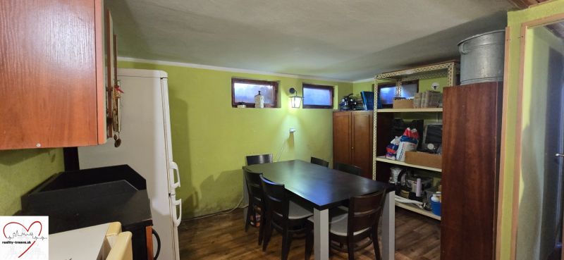 Interior of a cottage with a dining table, a wardrobe, and shelves, floor with wooden decor.