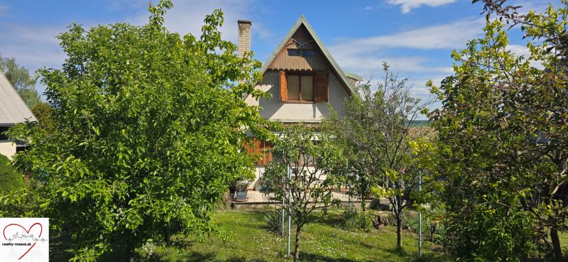 A cottage on Nové Vinohrady Street in Suchá nad Parnou surrounded by greenery and trees.