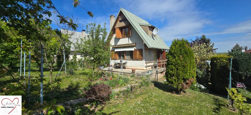 A cottage in Nové Vinohrady in Suchá nad Parnou surrounded by a green garden.