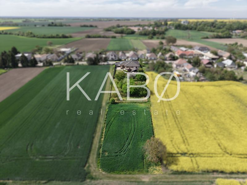 A family house on Močenská Street in Cabaj-Čápor surrounded by green and yellow fields.