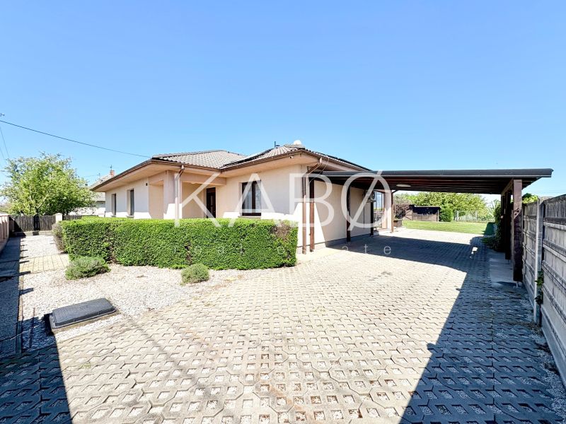 A family house on Močenská Street in Cabaj-Čápor with a covered parking space and a live hedge.