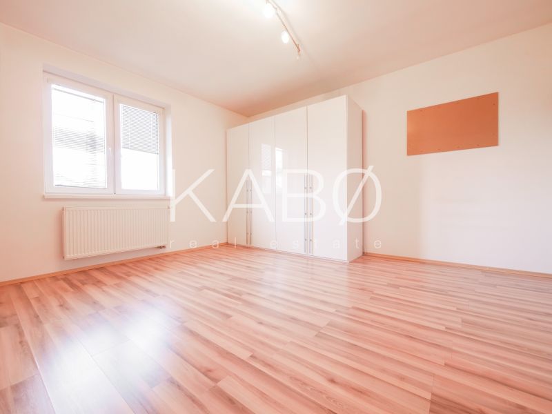 A room in a family house with a wooden decor floor and a wardrobe.