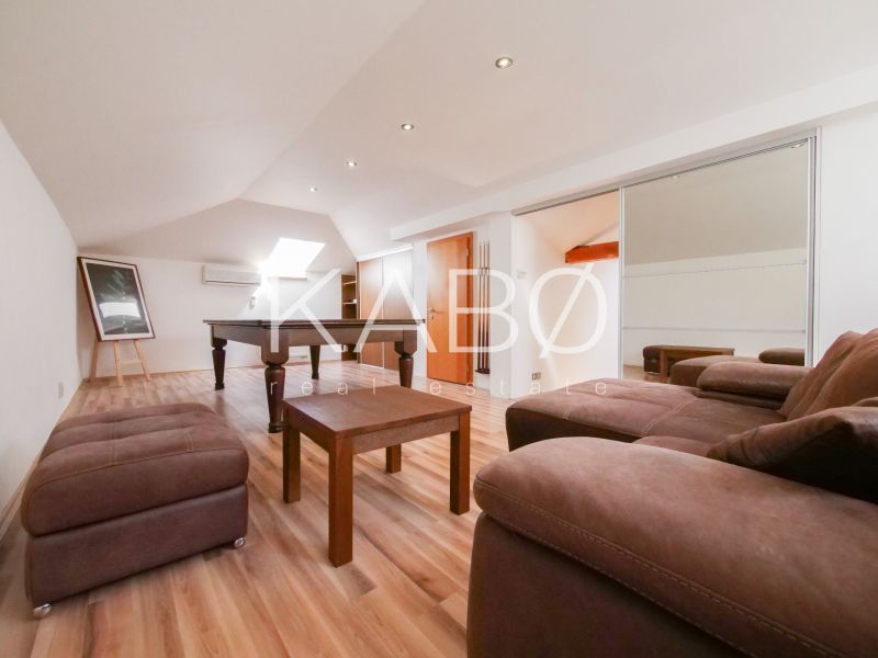 Living room in a family house with a pool table and a wooden decor floor.