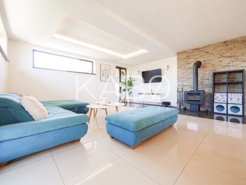 Living room in a family house with a fireplace, sofa, and light floors.