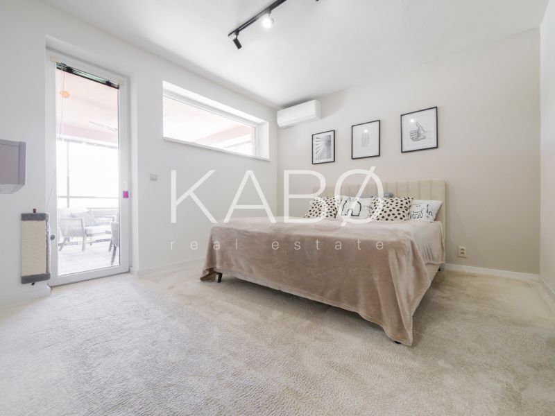 Bedroom in a family house with a light wall, bed, and air conditioning.