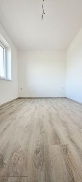 An empty room with a wooden decor floor in a family house.