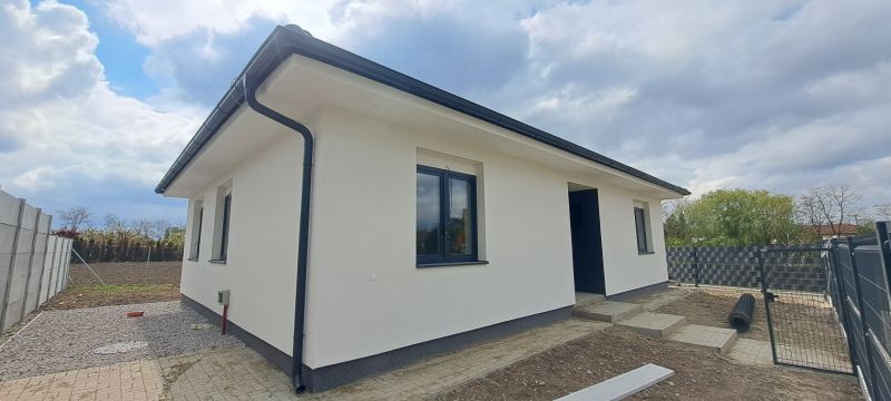 A family house in Selice with a white facade and black roofing elements.