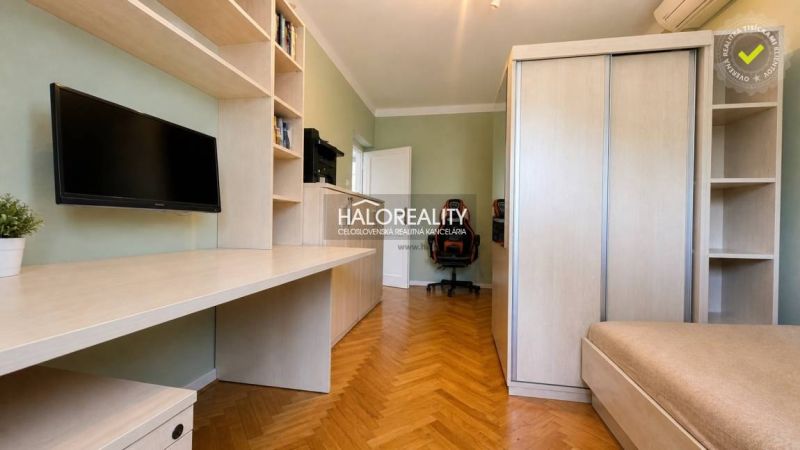 A study in a 3-room apartment with shelves, a desk, and a floor with a wood decor.