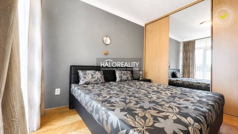 Bedroom with a double bed, mirrored wardrobe, and wooden decor flooring in a 3-room apartment.
