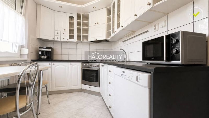 A kitchen in a 3-room apartment with a white kitchen unit and appliances.
