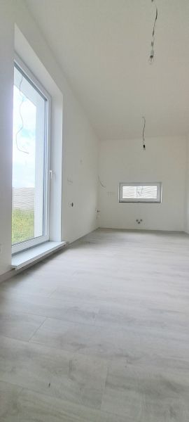Interior of a family house with a wooden decor floor and a large window.