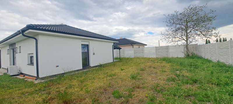 A family house in Topoľnica with a white facade, garden, and fence.