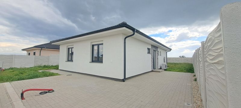 A family house in Topoľnica with a white facade and a paved courtyard.