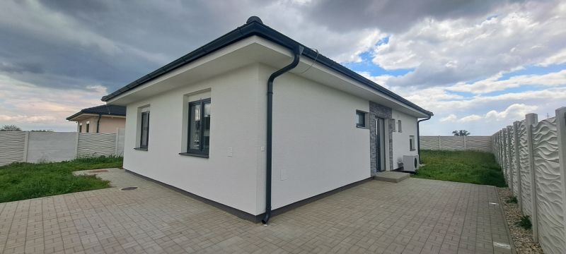 A family house in Topoľnica with a white facade and a paved terrace.