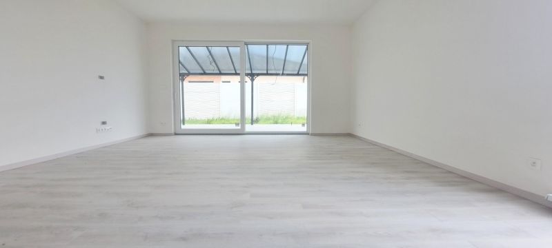 Spacious bright interior with wood-patterned flooring of a family house.
