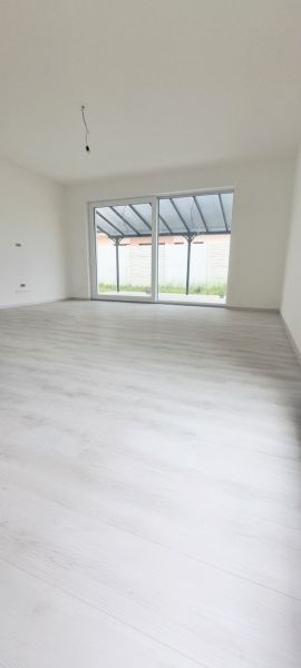 Interior of a family house with a large window and a wooden decor floor.