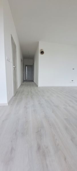 Interior of a family house with white walls and a floor with a wood decor.