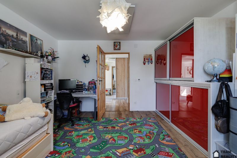 Children's room in a family house with a colorful carpet and a desk.