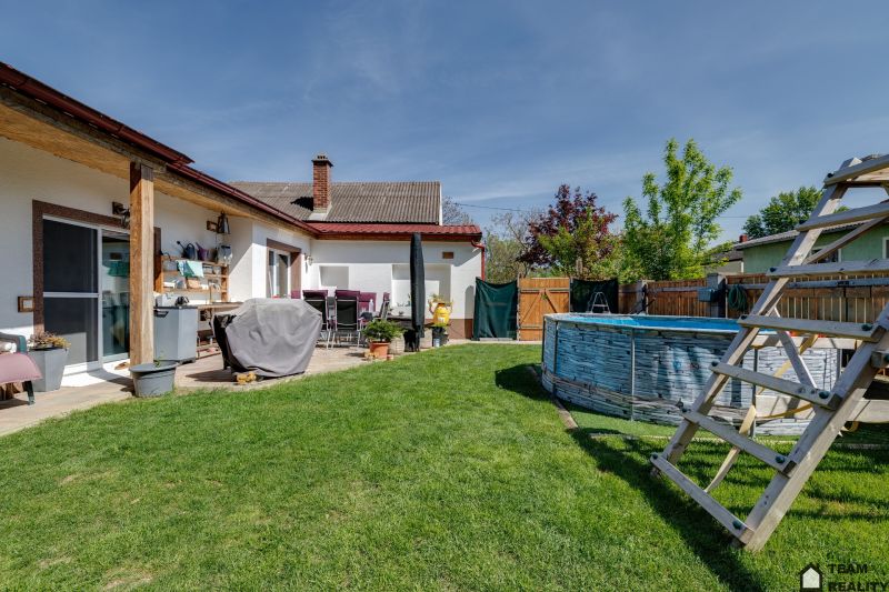 Family house in Potzneusiedl with a pool and a terrace in a sunny yard.