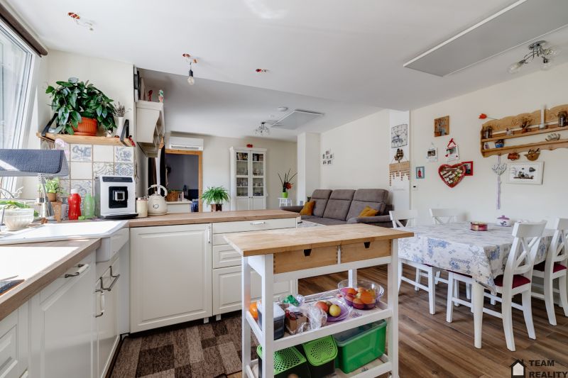 Kitchen and dining area with a sofa in a family house. Floor with wooden decor.