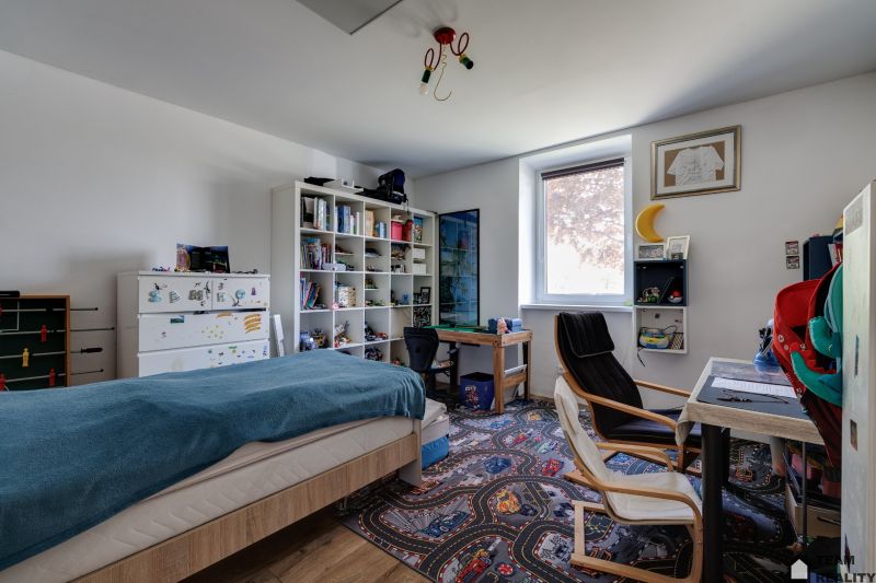 A children's room in a family house with a decorative carpet and shelves for toys.