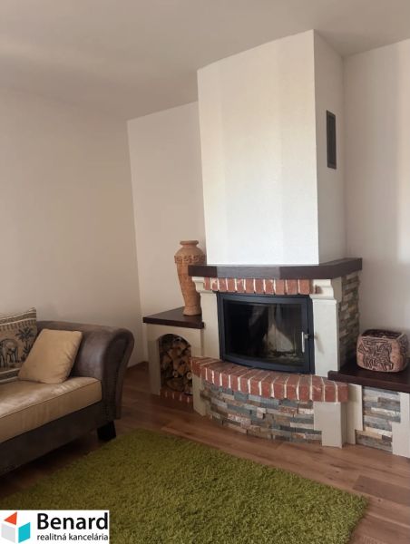 The 3-room apartment features a fireplace with brick details and a comfortable sofa.
