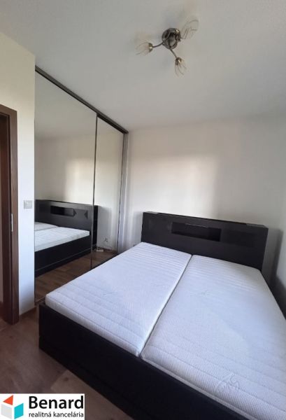 Bedroom in a 3-room apartment with a double bed, mirrored wardrobe, and wooden decor flooring.