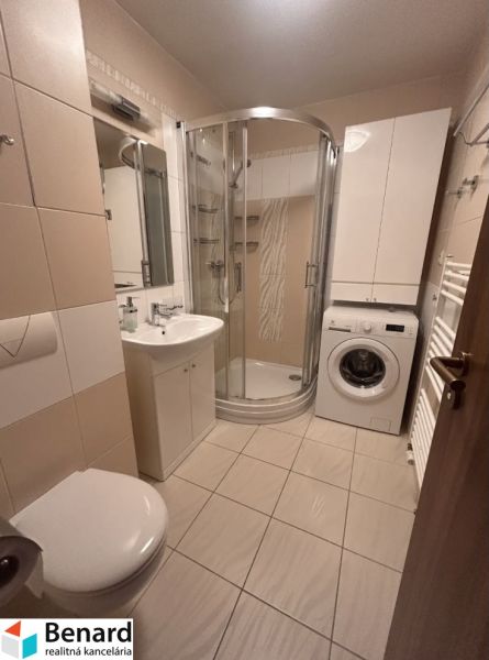 Bathroom in a 3-room apartment with a bathtub, washing machine, and storage space.