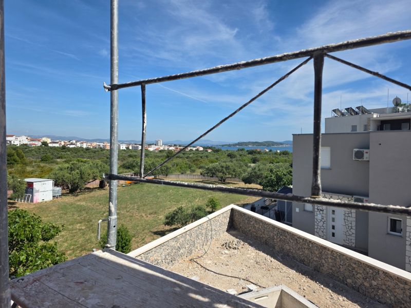 The view from the 3-room apartment in TRIBUNJ shows a construction site and a panorama with the sea.