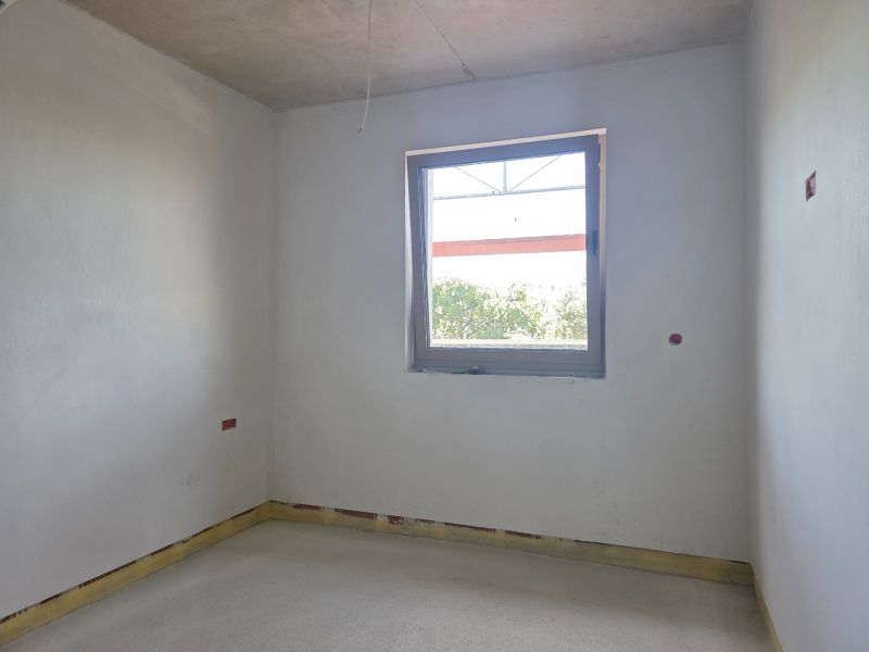An empty room with a window in a 3-room apartment ready for further modifications.