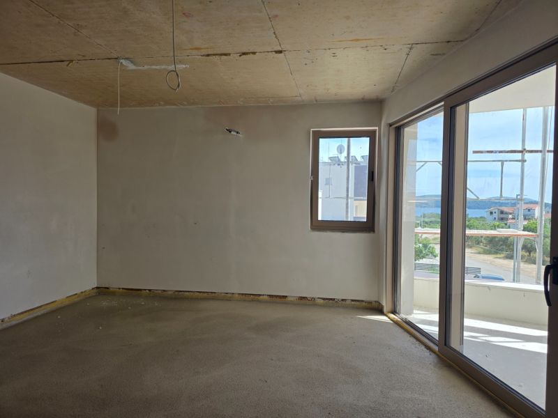 Interior of a 3-room apartment with a balcony and a view of the countryside.