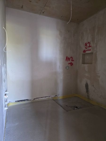 Interior of a 3-room apartment with wall plastering and marked locations for installations.