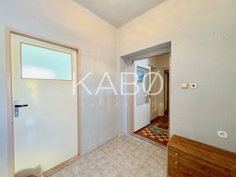 In the family house, there are two white doors, gray walls, and tiles.