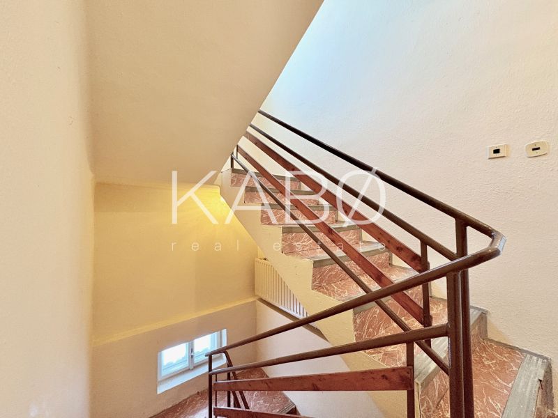 A staircase with a brown railing in a family house.