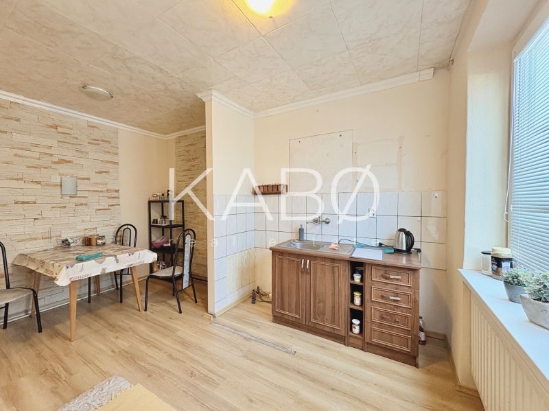 A kitchen in a family house with a wooden decor floor and a dining table.