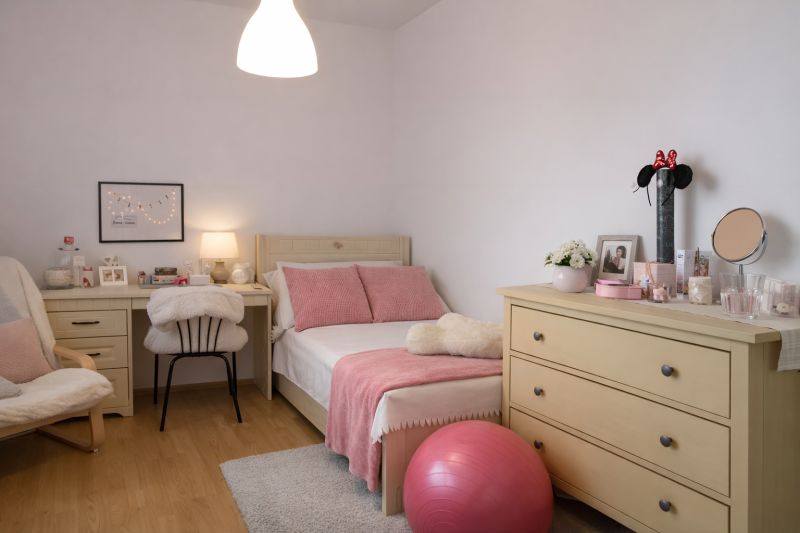 A room in a 4-room apartment with a bed, dresser, desk, and decorations.