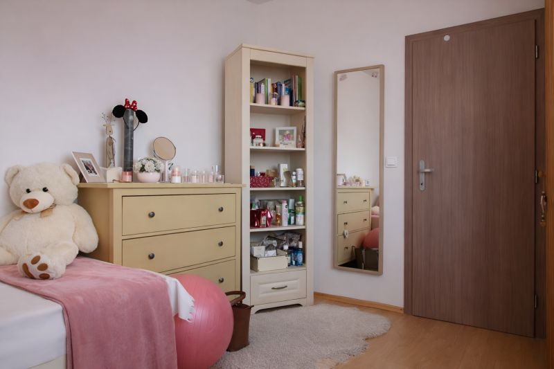 Children's room with a wardrobe, mirror, large plush teddy bear, and floor with wooden decor.