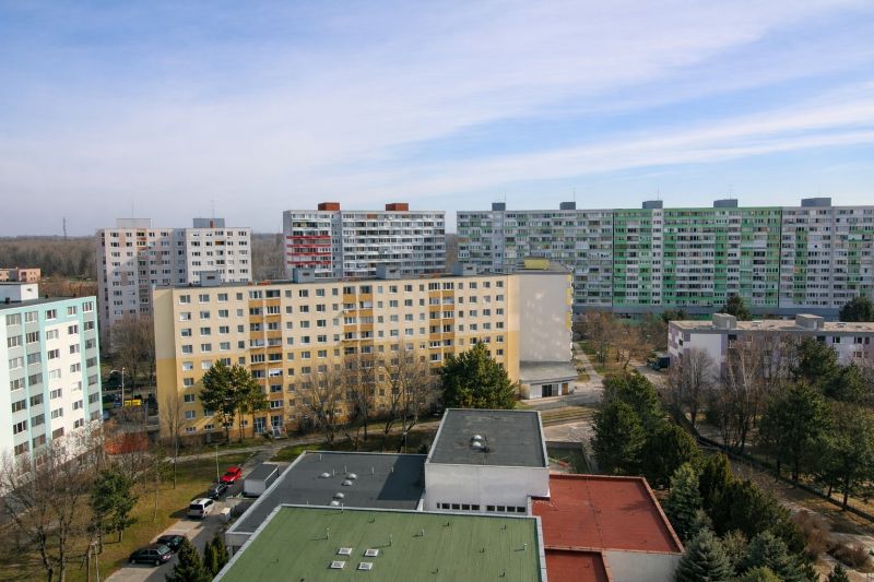 Apartment buildings in Bratislava - Petržalka on Lietavská Street in the background of trees.