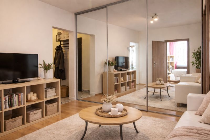 Living room with a mirrored wardrobe, television, and wooden decor flooring.