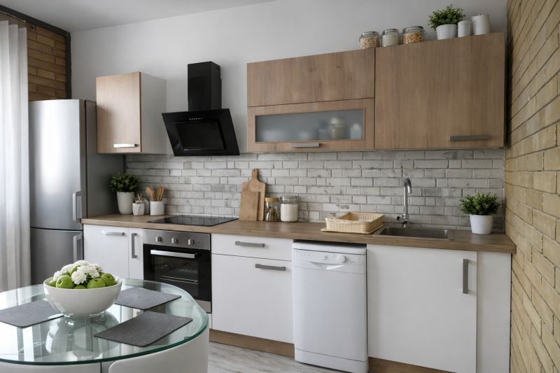 A kitchen in a 4-room apartment with matte white and wooden cabinets and a glass table.