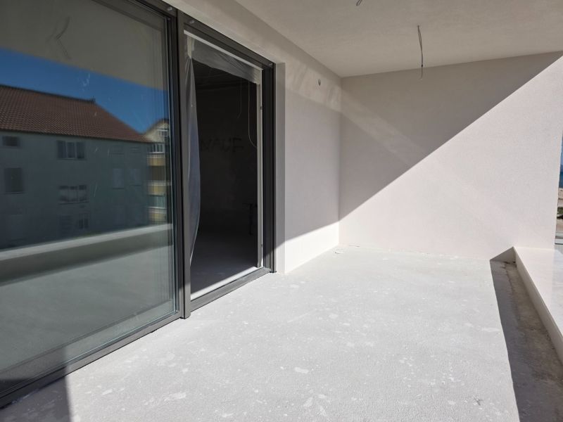 A balcony of a 3-room apartment in the city of Srima with access through large sliding doors.