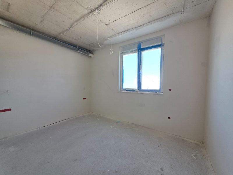 A room in a 3-room apartment with white walls and a window.