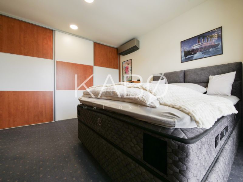 A bedroom in a family house with a large bed and a sliding wardrobe.